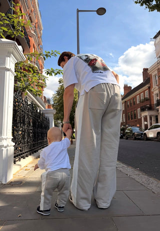 Man and toddler walking hand in hand in matching grey Core joggers