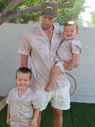 Man and two boys wearing matching Palm Shadow linen shirts outdoors
