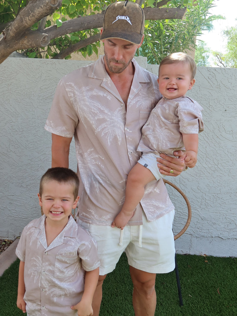 Man and two boys wearing matching Palm Shadow linen shirts outdoors