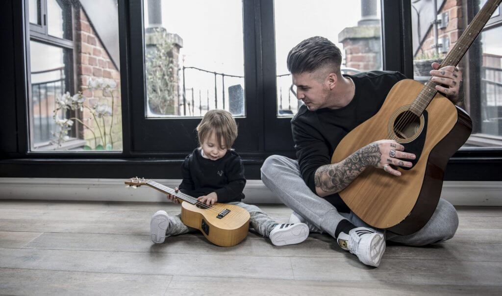 son imitating father playing guitar